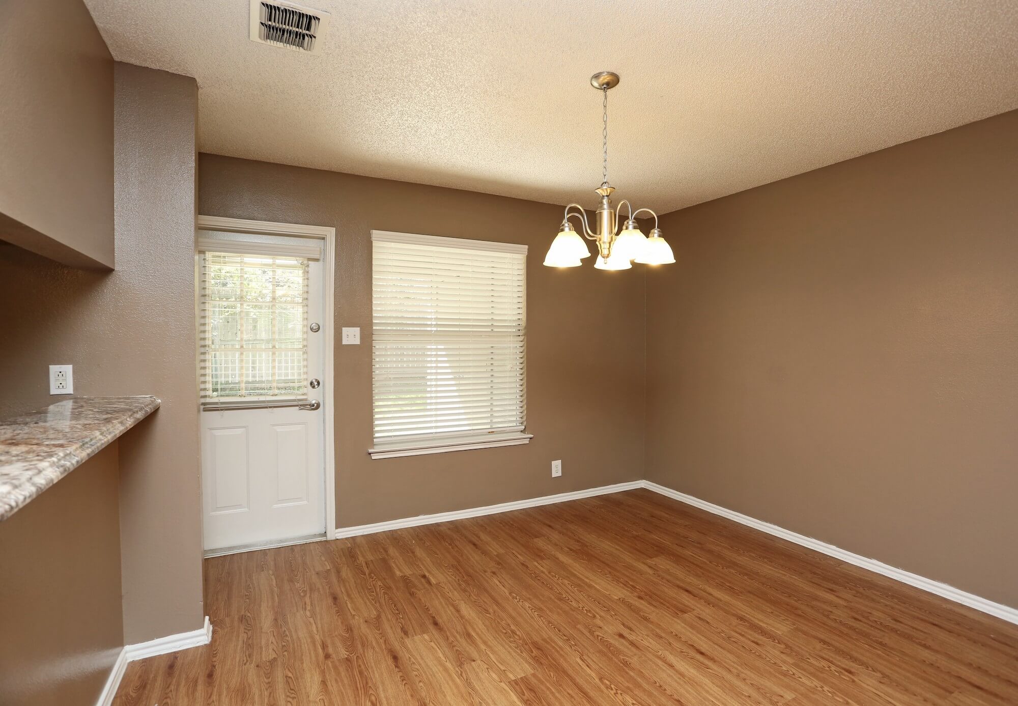 Dining area with low-hung lighting and entrance to patio.