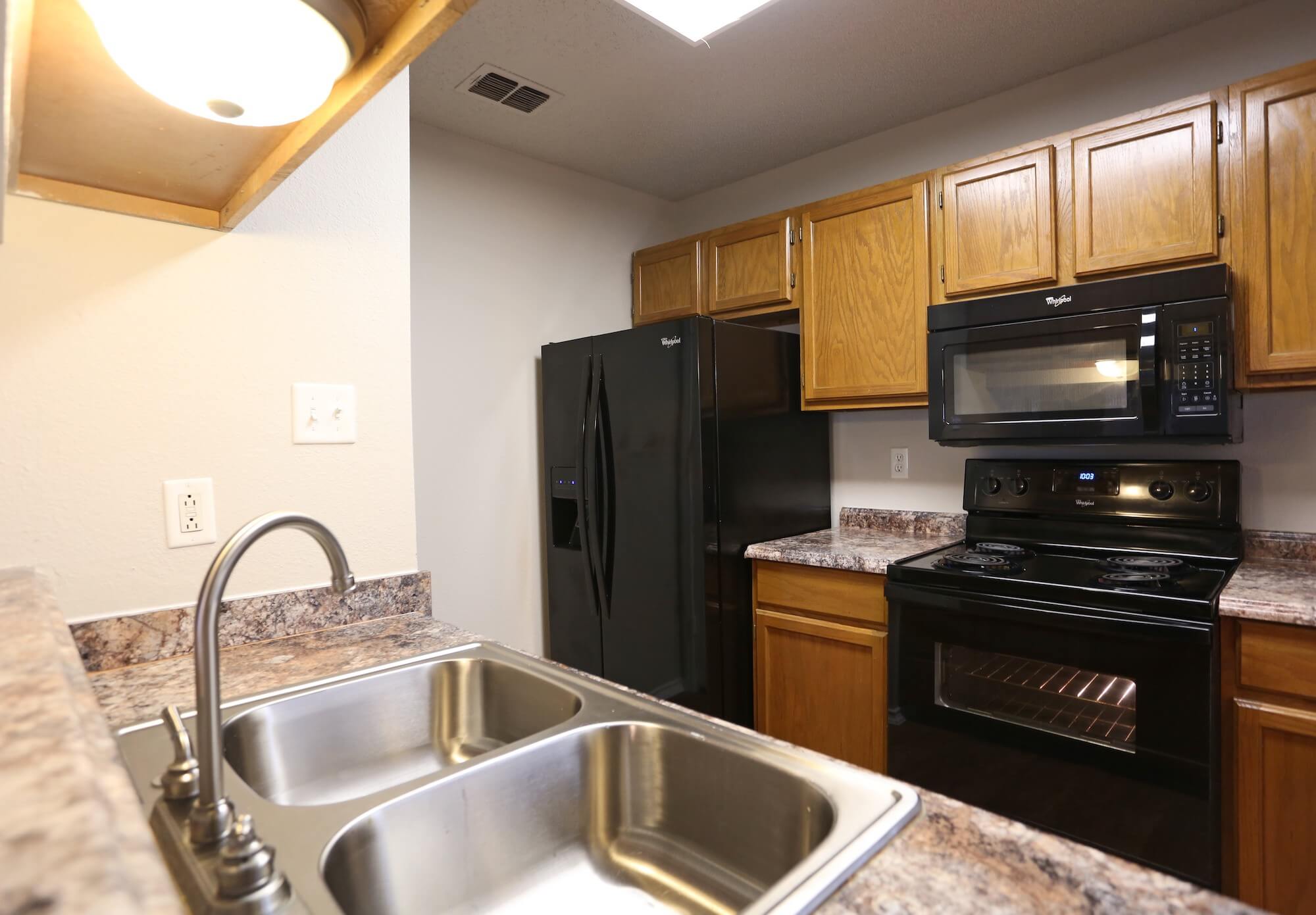 Full kitchen with black appliances.