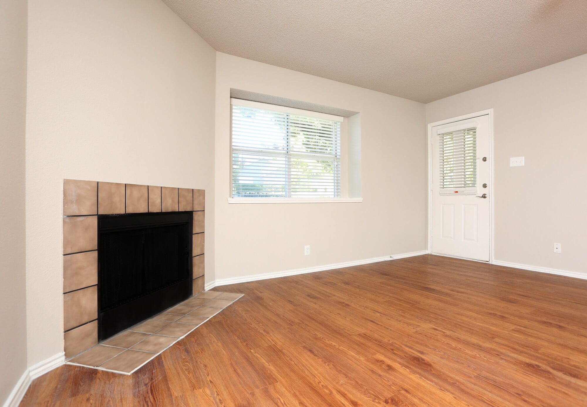 Large living room with bright windows and fireplace.