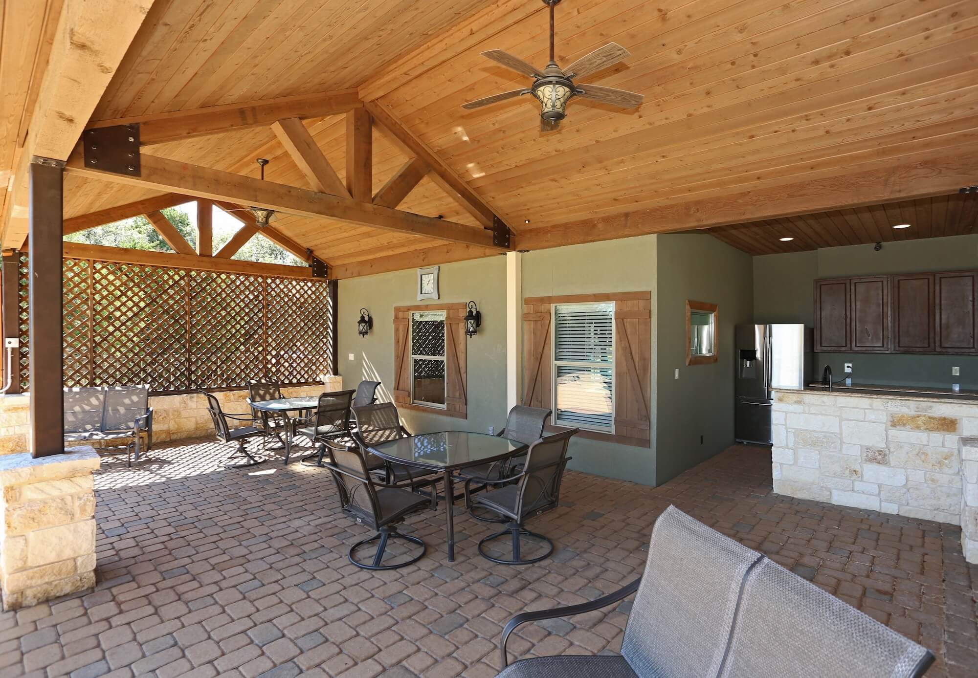 The community pool lounge with outdoor kitchen, tables, chairs, and ceiling fans for a fun outdoor experience.